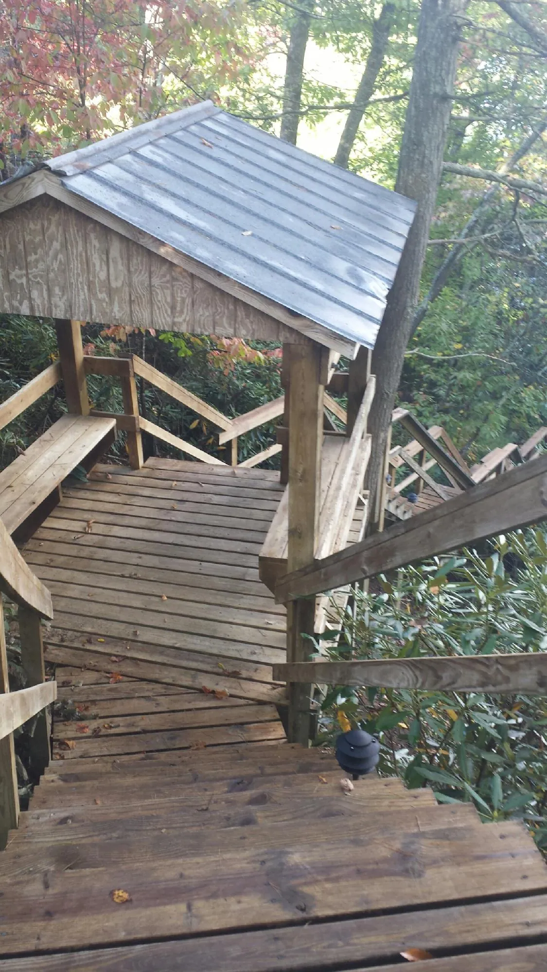Metal roofed shelter over wooden steps on a wooded walkway — Skylight Repair & Installation work by our crew in Sutherland Springs