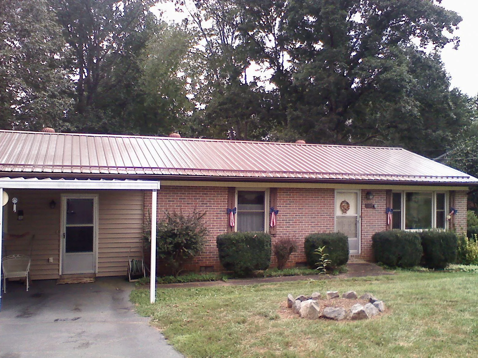 Bronze metal roof and carport on a brick ranch home — Roof Repair work by our crew in Sutherland Springs