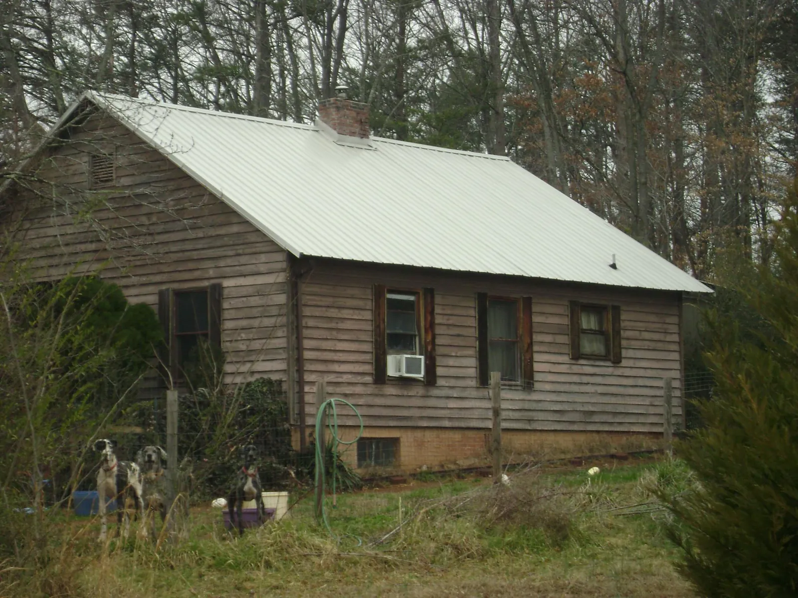 White metal roof on an old wood sided farmhouse, from a Metal Roof Installation job in Sutherland Springs
